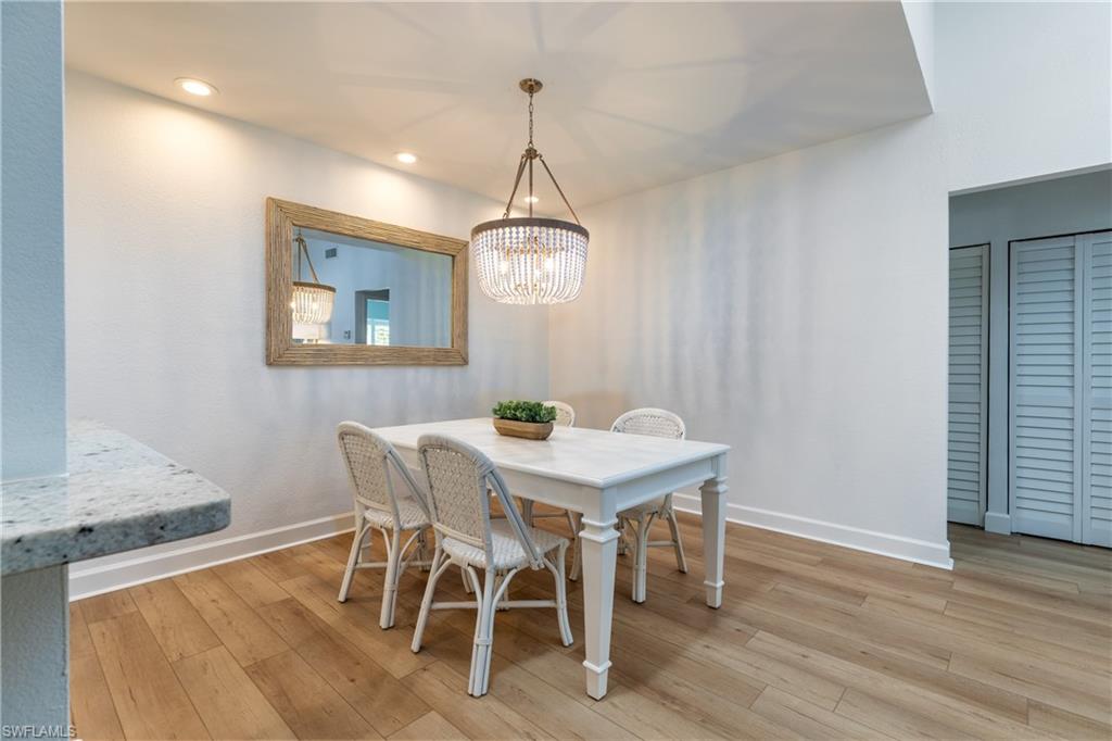 790 Willowbrook Drive, Unit 305 Naples, FL 34108 - Photo 4 of 23 a view of a dining room with furniture and wooden floor