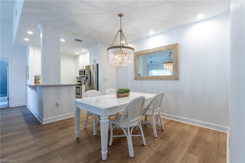790 Willowbrook Drive, Unit 305 Naples, FL 34108 - Photo 5 of 23 a view of a dining room with furniture window and wooden floor