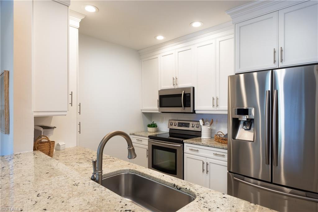 790 Willowbrook Drive, Unit 305 Naples, FL 34108 - Photo 7 of 23 a kitchen with stainless steel appliances a refrigerator sink and microwave