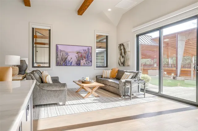 a living room with furniture kitchen view and a large window