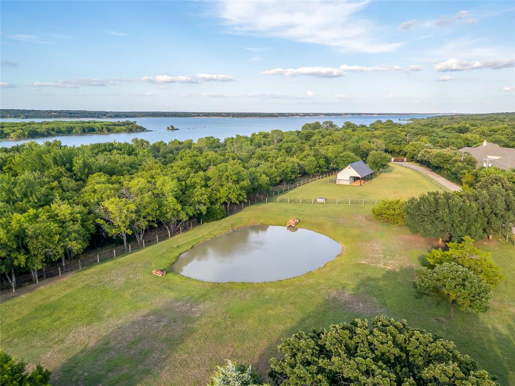 5000 T W King Road Southlake, TX 76092 - Photo 5 of 40 a view of a swimming pool with a yard and lake view in back