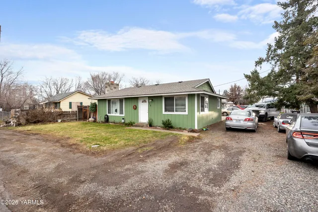 a front view of a house with a garden and parking space