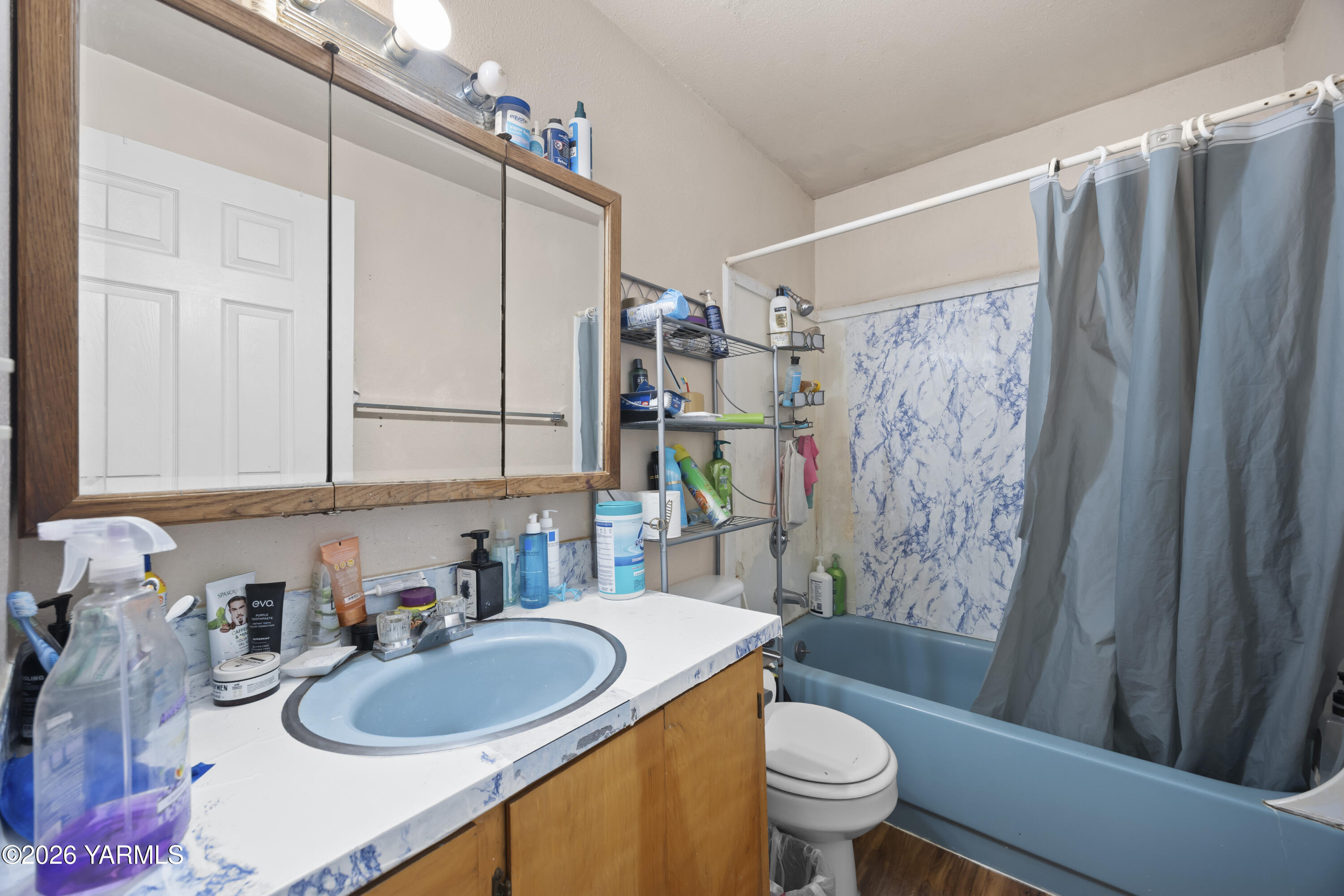 115 East D Street Wapato, WA 98951 - Photo 7 of 28 a bathroom with a sink a toilet and shower curtain