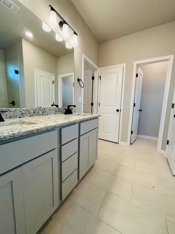 a bathroom with a glass shower door and a sink