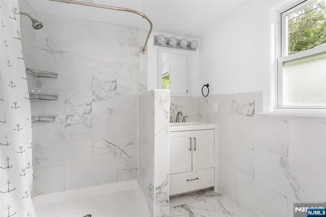 a bathroom with a shower sink and mirror