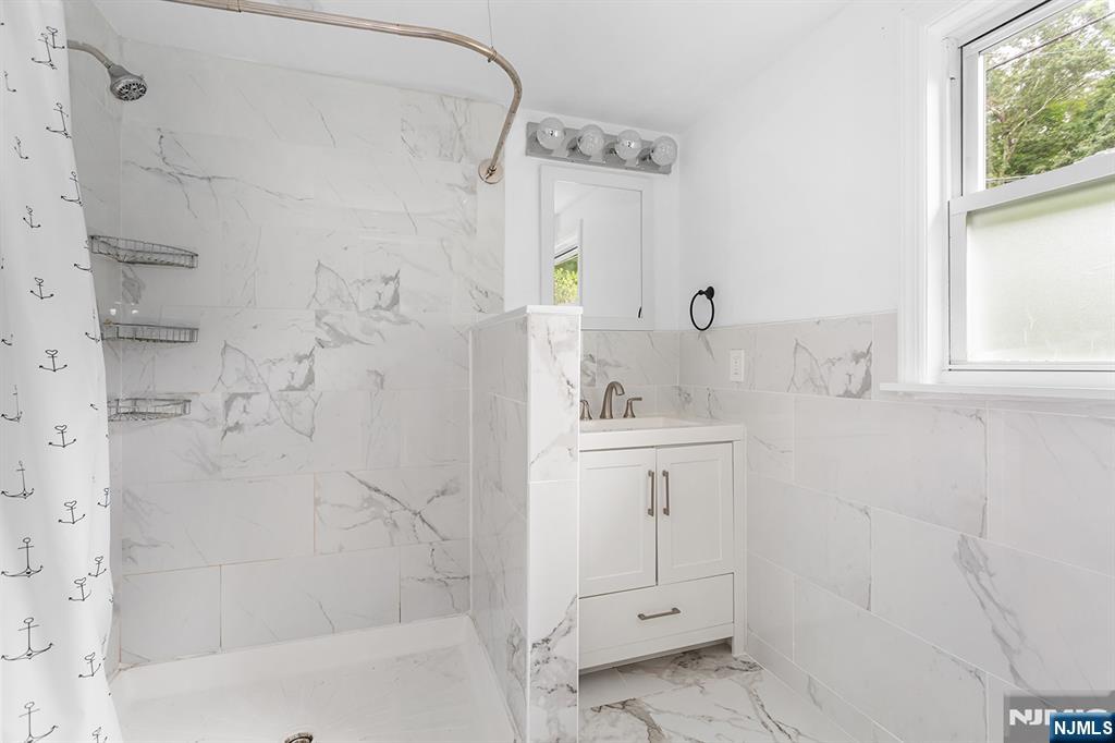 67 Nolans Point Road Lake Hopatcong, NJ 07849 - Photo 18 of 43 a bathroom with a shower sink and mirror