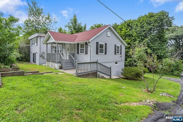 a front view of a house with yard and green space