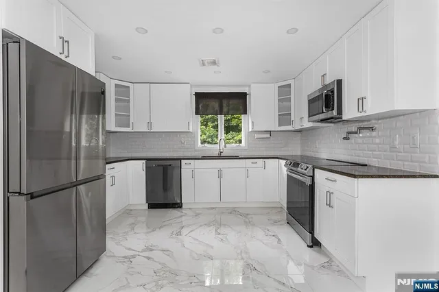 a kitchen with stainless steel appliances granite countertop a refrigerator sink and microwave