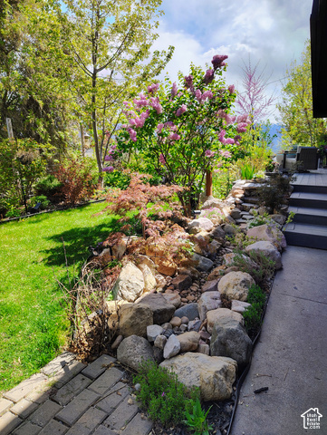 1397 Ritter Drive Riverdale, UT 84405 - Photo 15 of 21 Manicured lawn with mature trees, established flowering shrubs, and a tiered rock garden