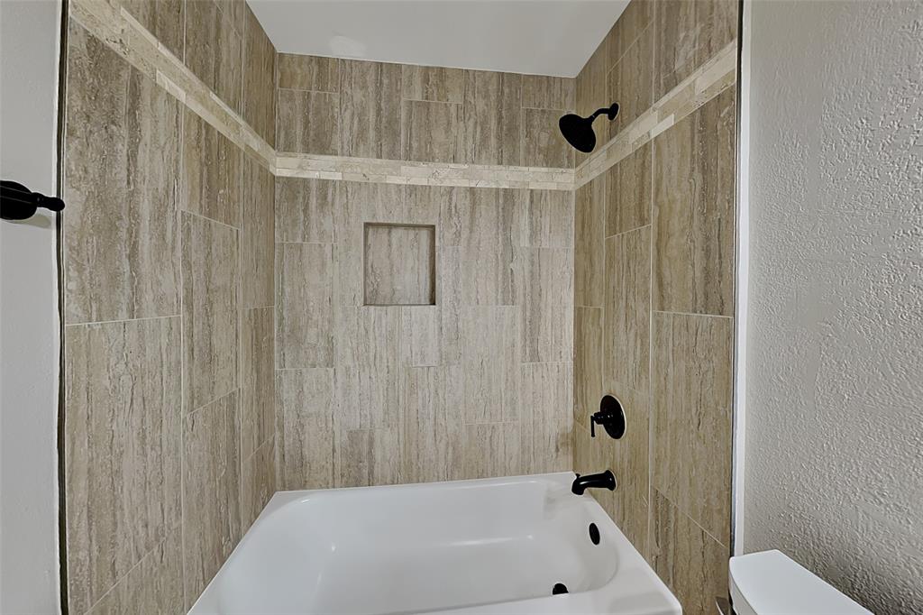 1008 Timberline Lane Allen, TX 75002 - Photo 19 of 25 a bathroom with a bathtub a toilet and a shower