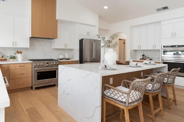 a kitchen with stainless steel appliances granite countertop a sink stove and refrigerator