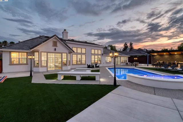 a view of a house with swimming pool and sitting area