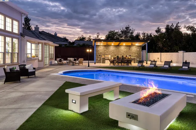 a living room with furniture kitchen area and a large window