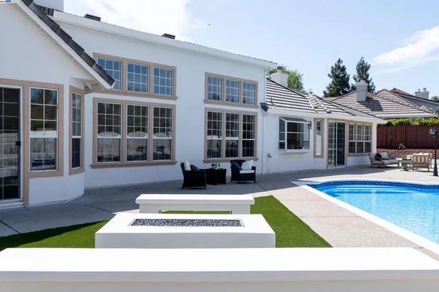 a view of a house with swimming pool and sitting area