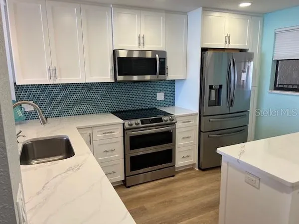 a kitchen with a sink and a stove top oven