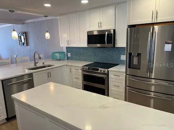 a kitchen with a sink stainless steel appliances and cabinets