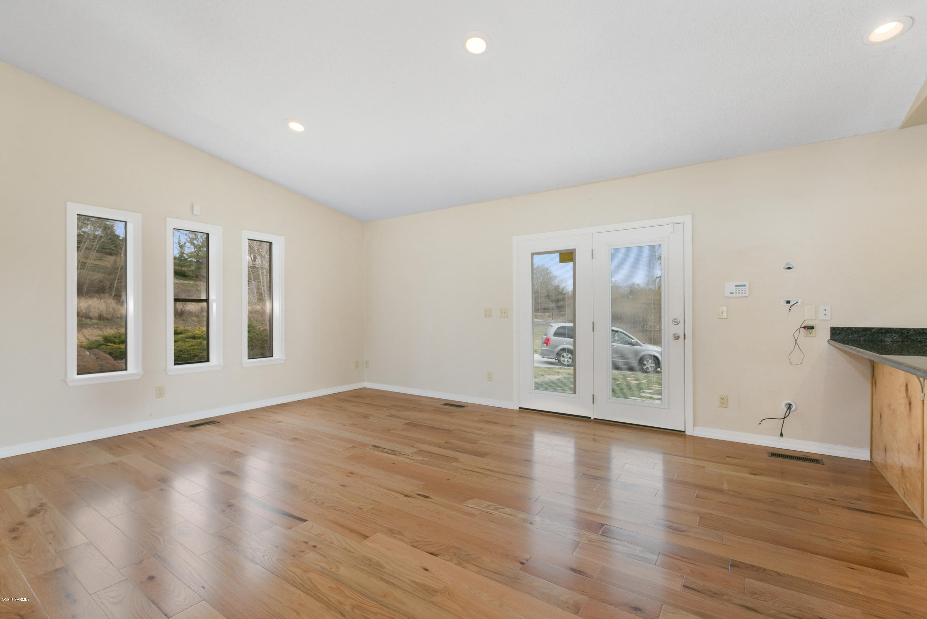1004 Birchfield Road Yakima, WA 98901 - Photo 11 of 23 a view of an empty room with wooden floor and a window