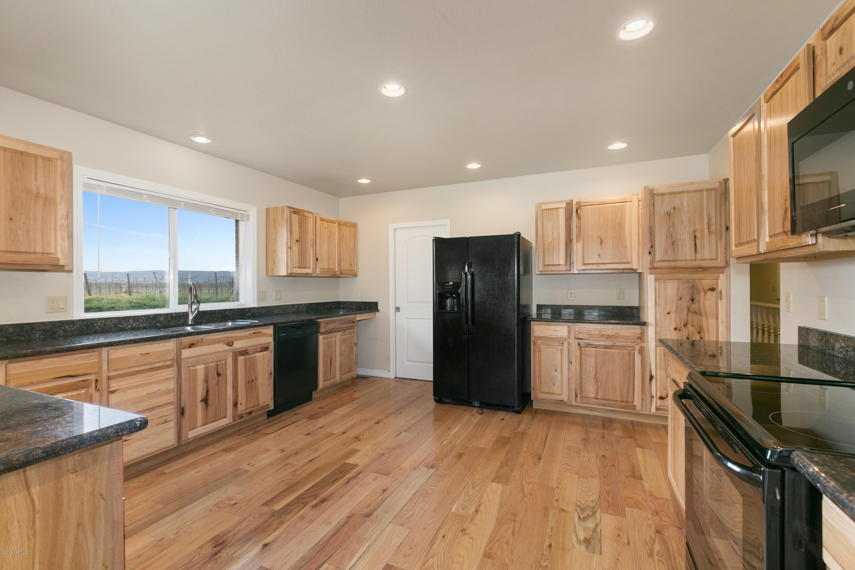 1004 Birchfield Road Yakima, WA 98901 - Photo 12 of 23 a kitchen with granite countertop a refrigerator and a stove top oven