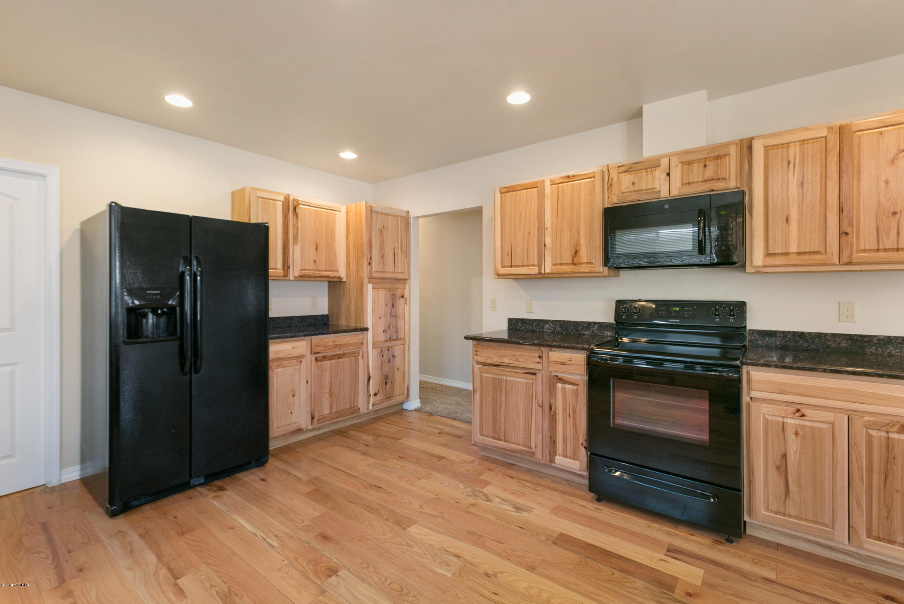 1004 Birchfield Road Yakima, WA 98901 - Photo 13 of 23 a kitchen with granite countertop a refrigerator stove and microwave