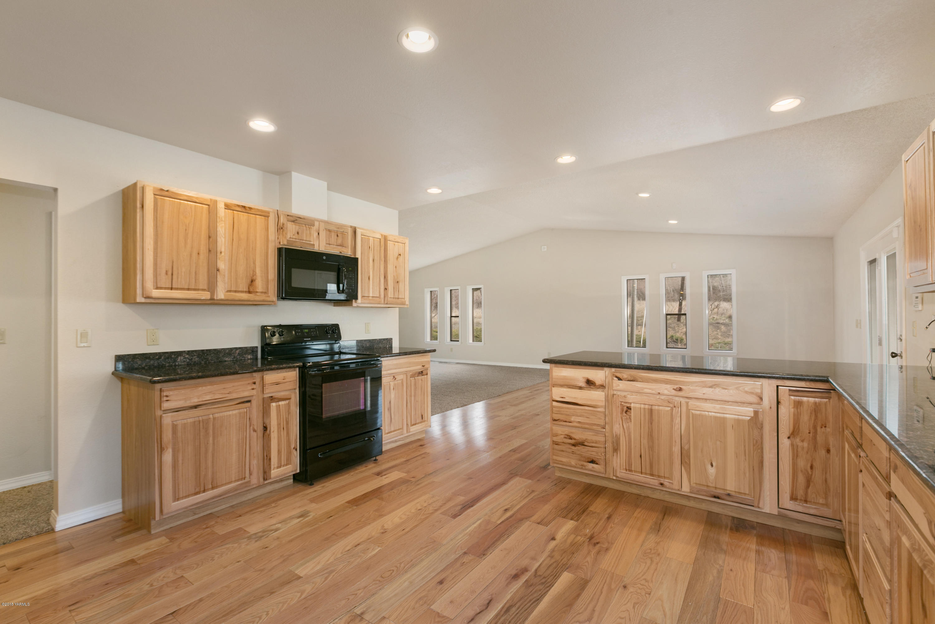 1004 Birchfield Road Yakima, WA 98901 - Photo 14 of 23 a large kitchen with cabinets wooden floor and stainless steel appliances