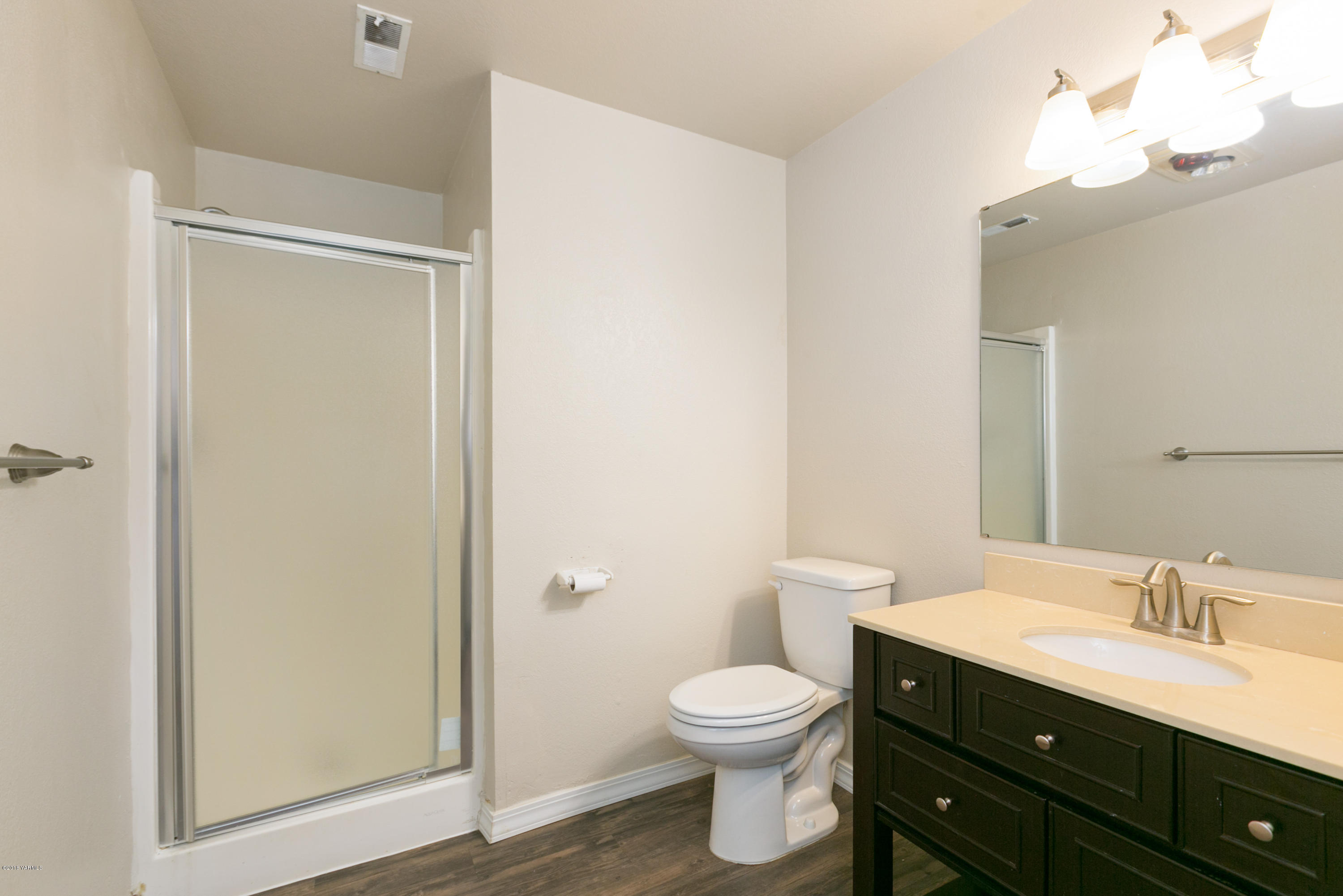 1004 Birchfield Road Yakima, WA 98901 - Photo 21 of 23 a bathroom with a toilet a sink a mirror and vanity