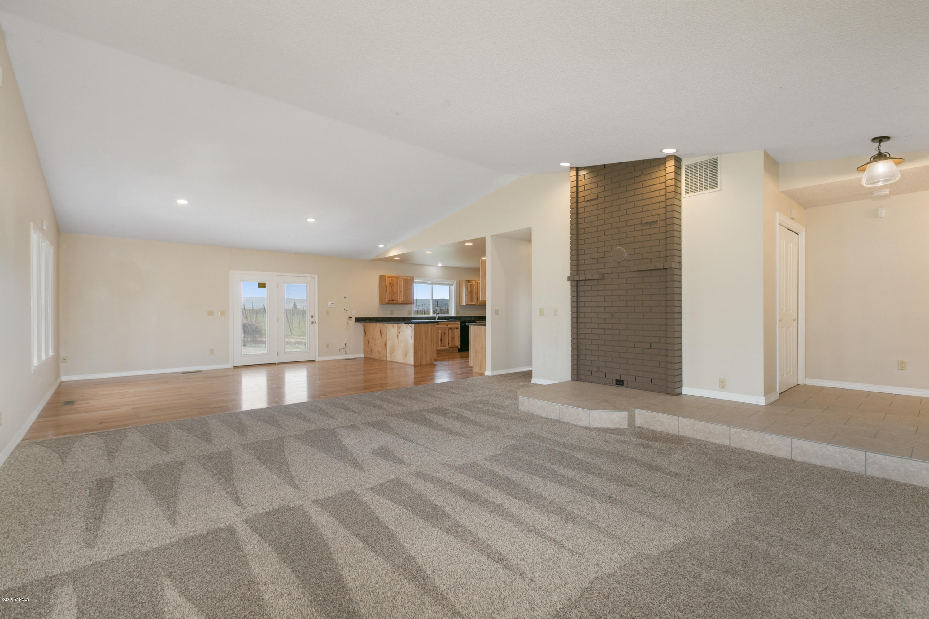 1004 Birchfield Road Yakima, WA 98901 - Photo 9 of 23 a view of empty room with wooden floor and kitchen
