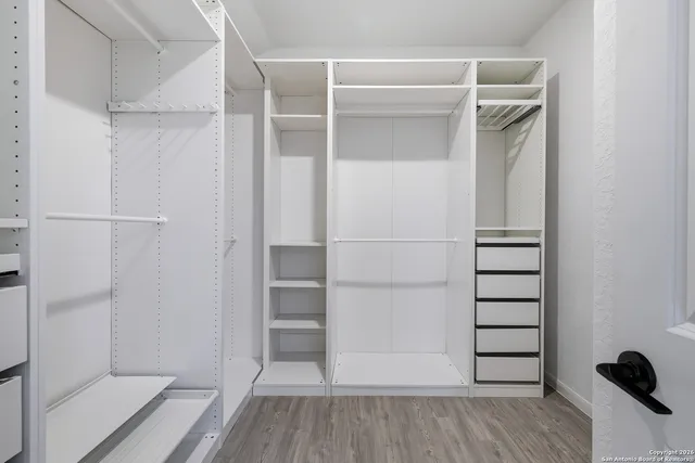 a view of walk in closet with empty racks