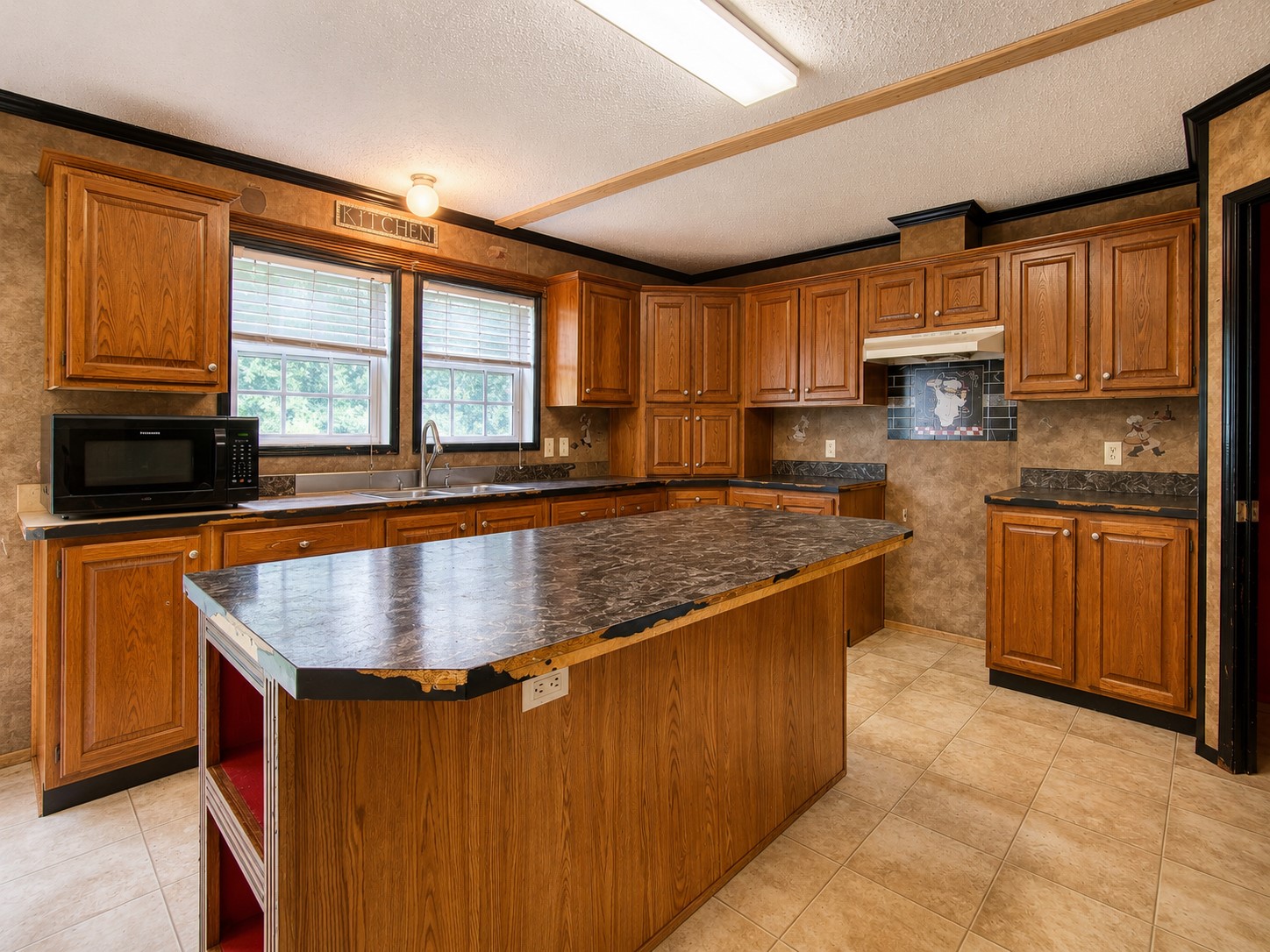 461924 East 1140 Road Sallisaw, OK 74955 - Photo 11 of 29 Functional kitchen featuring abundant wood cabinetry, an expansive island, dual windows, and tiled flooring