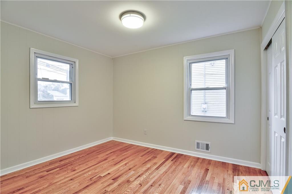 113 Stony Road Edison, NJ 08817 - Photo 13 of 20 a view of an empty room with wooden floor and a window