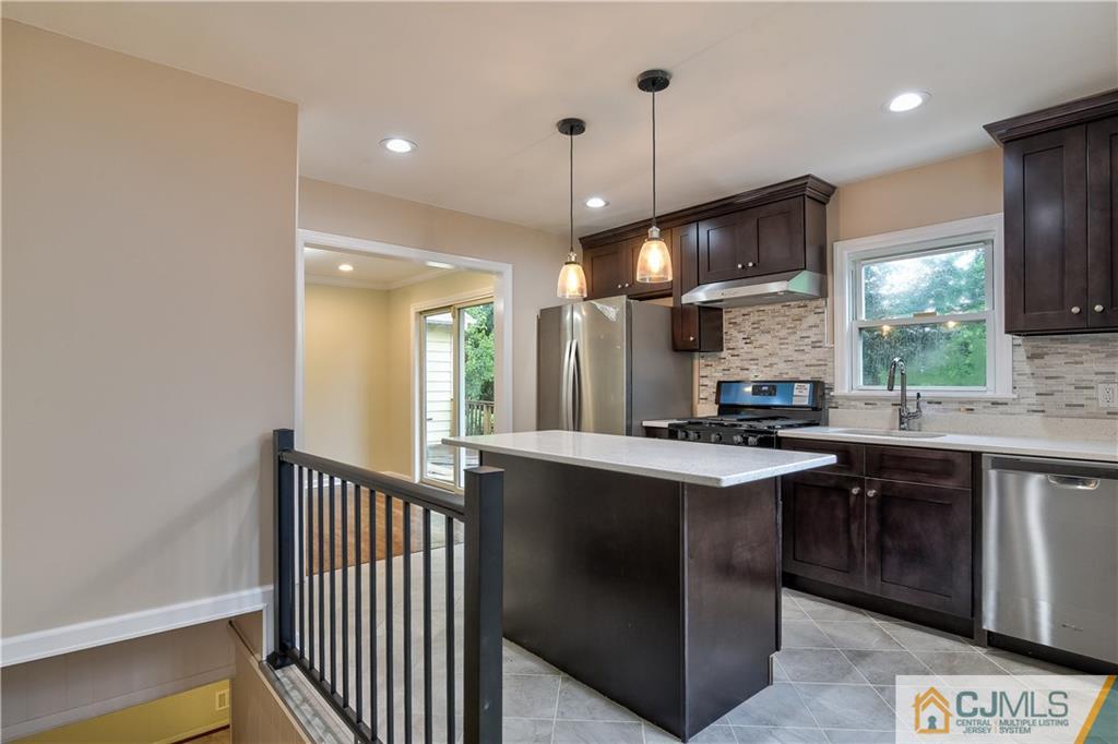 113 Stony Road Edison, NJ 08817 - Photo 7 of 20 a kitchen with stainless steel appliances granite countertop a sink a stove and a refrigerator