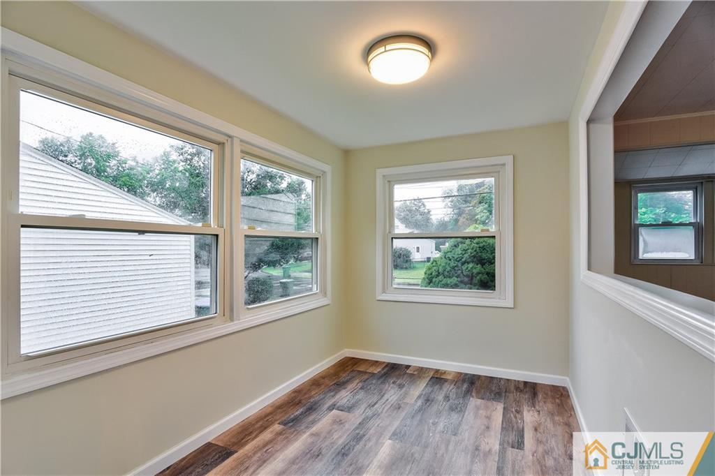 113 Stony Road Edison, NJ 08817 - Photo 9 of 20 an empty room with wooden floor and windows