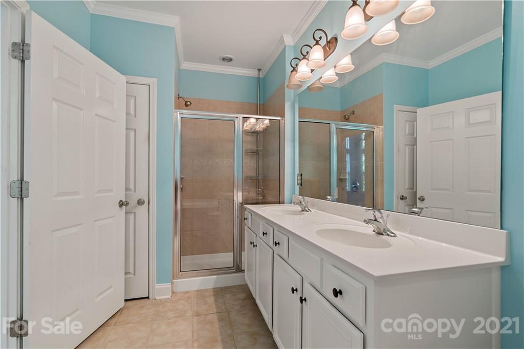 8929 Rosalyn Glen Road, Unit 108 Cornelius, NC 28031 - Photo 18 of 28 a bathroom with a double vanity sink mirror and shower