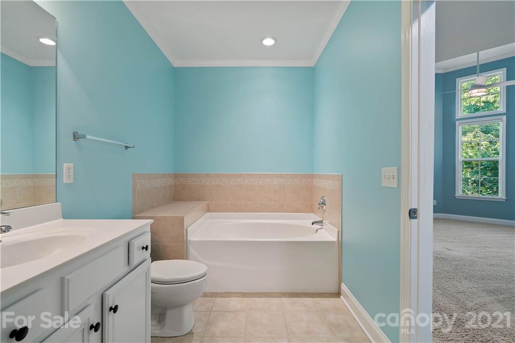 8929 Rosalyn Glen Road, Unit 108 Cornelius, NC 28031 - Photo 19 of 28 a bathroom with a toilet a sink and a bathtub