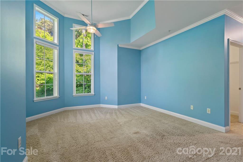 8929 Rosalyn Glen Road, Unit 108 Cornelius, NC 28031 - Photo 21 of 28 an empty room with windows and chandelier