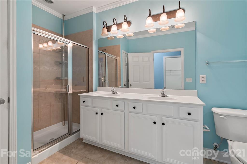 8929 Rosalyn Glen Road, Unit 108 Cornelius, NC 28031 - Photo 23 of 28 a bathroom with a double vanity sink mirror and toilet