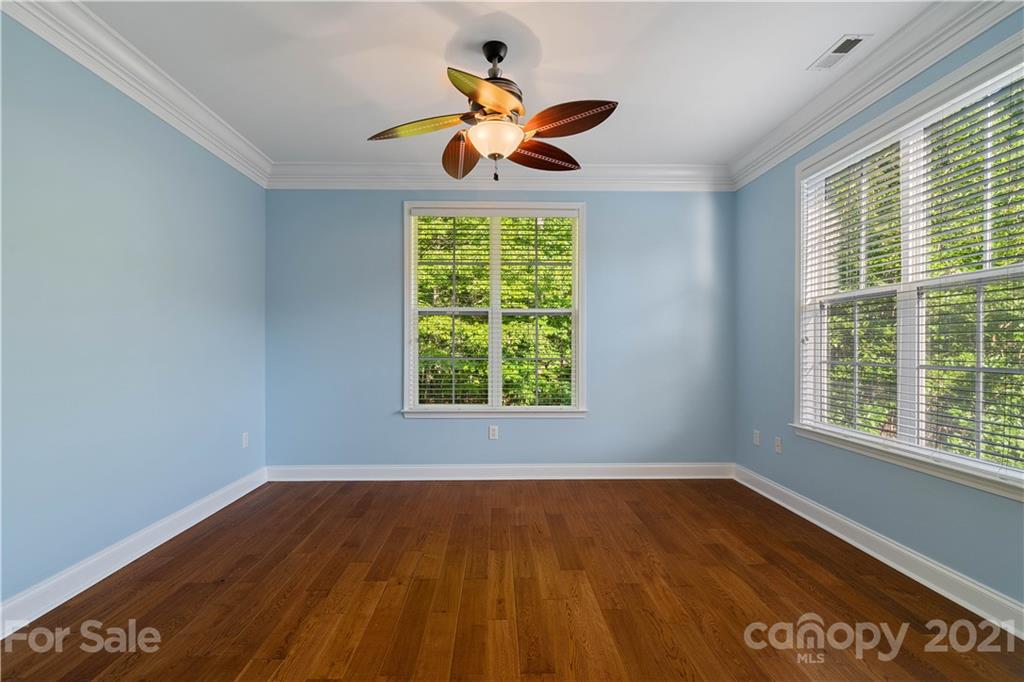 8929 Rosalyn Glen Road, Unit 108 Cornelius, NC 28031 - Photo 6 of 28 a view of an empty room with wooden floor and a window