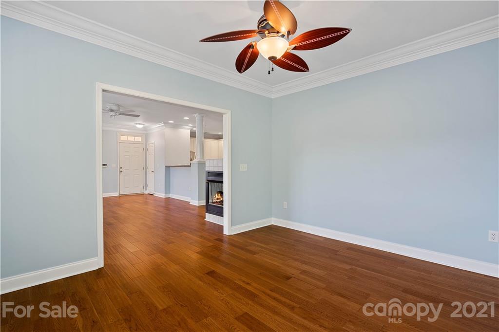 8929 Rosalyn Glen Road, Unit 108 Cornelius, NC 28031 - Photo 7 of 28 an empty room with wooden floor a ceiling fan and closet