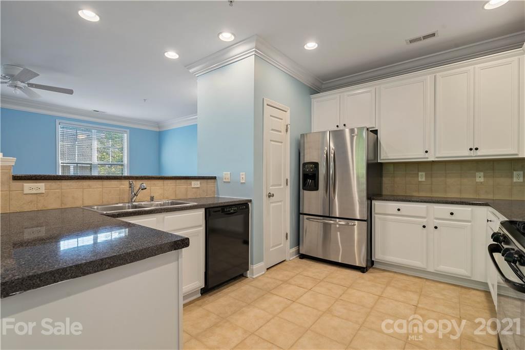8929 Rosalyn Glen Road, Unit 108 Cornelius, NC 28031 - Photo 10 of 28 a kitchen with granite countertop a refrigerator and a sink