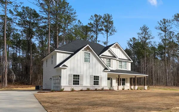 a front view of a house with a tree in it