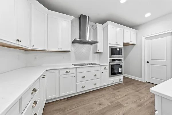 a kitchen with stainless steel appliances white cabinets and a refrigerator