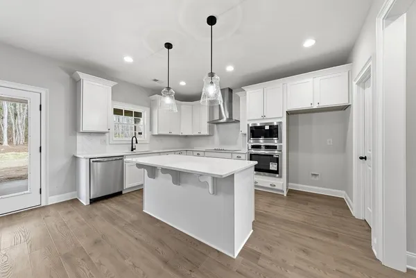 a kitchen with kitchen island a sink stainless steel appliances and cabinets