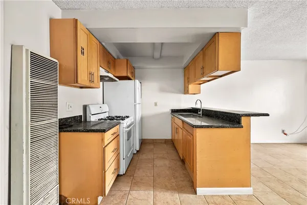 a kitchen with stainless steel appliances granite countertop a sink and a stove