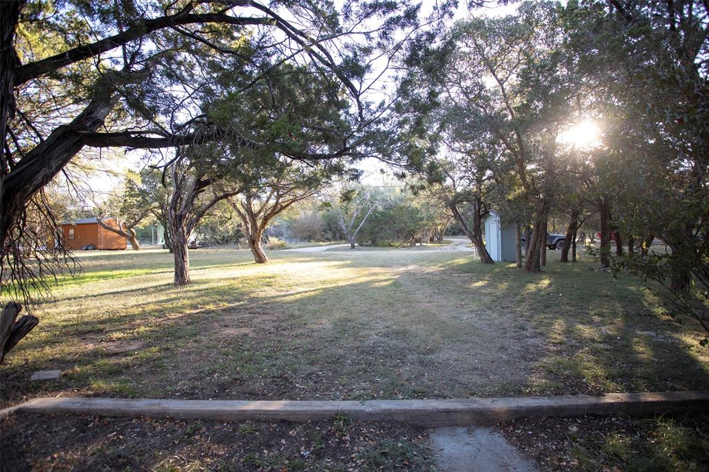9051 Lacy Road Graford, TX 76449 - Photo 5 of 23 Yard to the house from road. Ample room for an addition to the original home or space for a new lake home.