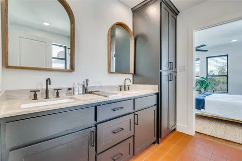 a en suite bathroom with a double vanity sink and a mirror