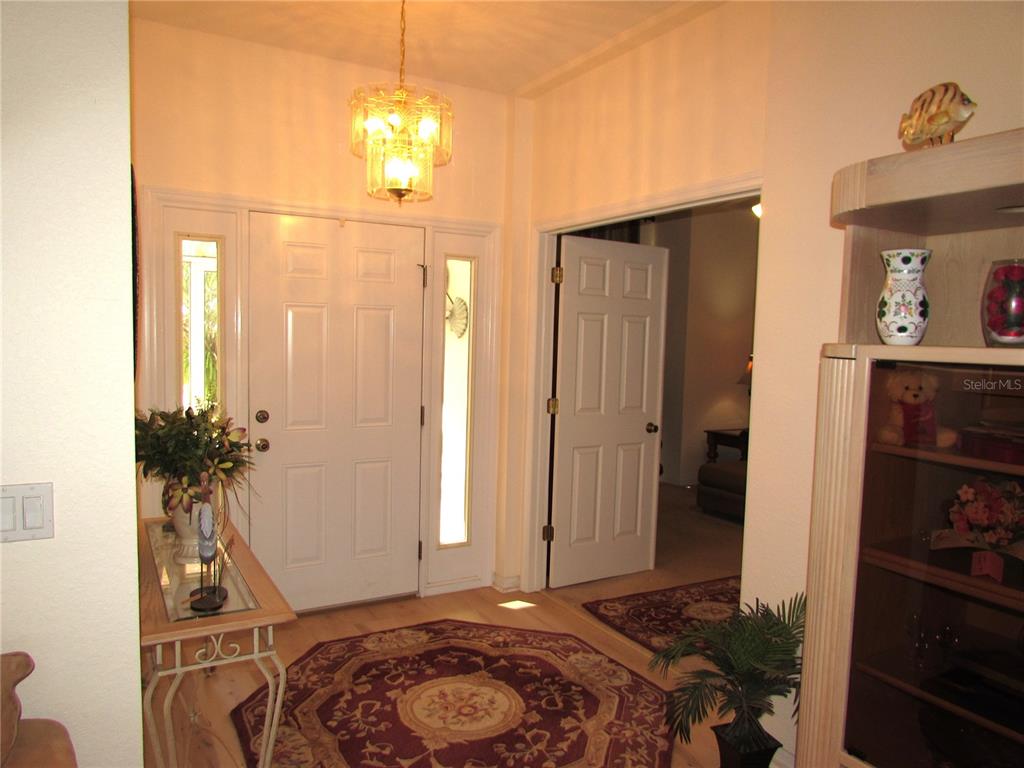 19367 Southwest 101st Place Road Dunnellon, FL 34432 - Photo 12 of 38 a bedroom with a bed and a chandelier