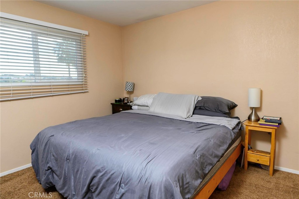 171 Brisco Road, Unit 8 Arroyo Grande, CA 93420 - Photo 12 of 23 a bedroom with a bed and wooden floor