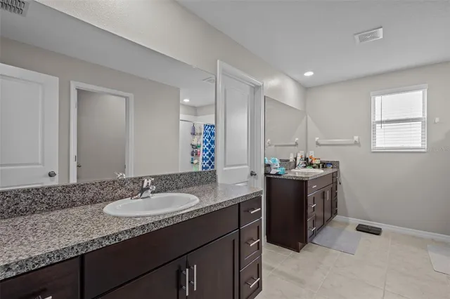 a bathroom with a granite countertop sink and a mirror