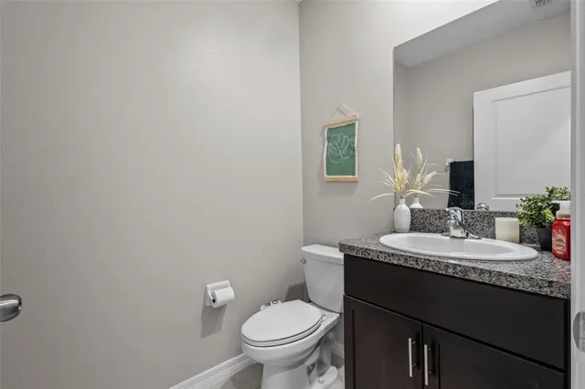 a bathroom with a granite countertop toilet sink and mirror