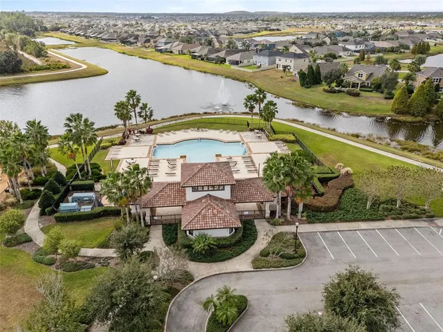 an aerial view of residential houses with outdoor space and lake view