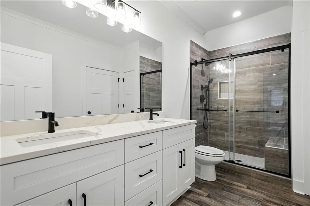 548 Stoneledge Road Jasper, GA 30143 - Photo 29 of 46 a bathroom with a double vanity sink toilet mirror and shower